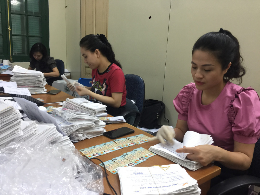 Cán bộ Phòng Cảnh sát QLHC về TTXH, CATP, kiểm tra thẻ CCCD gắn chíp điện tử trước khi bàn giao cho Bưu điện thành phố tổ chức trả thẻ cho người dân qua đường Bưu điện