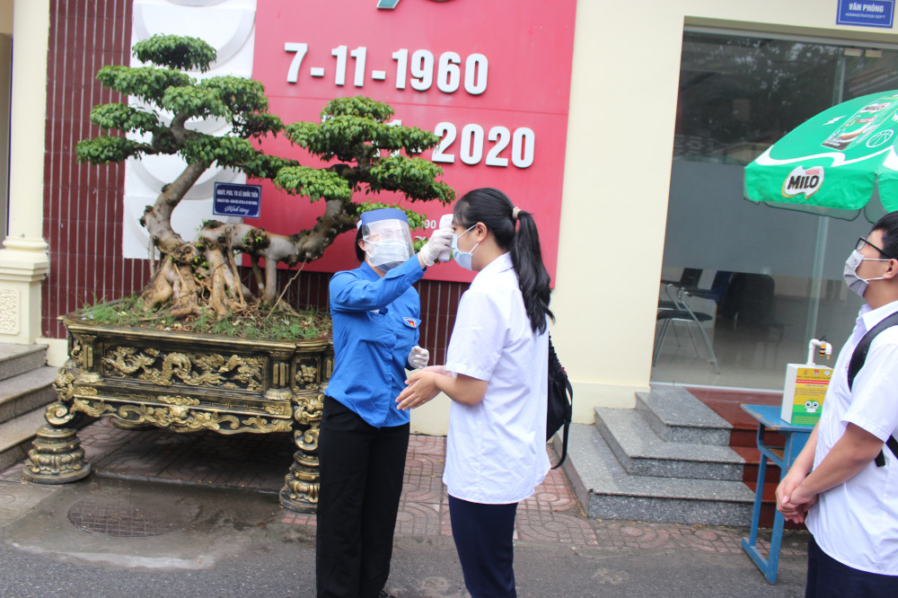 Các tình nguyện viên đo nhiệt độ cho thí sinh