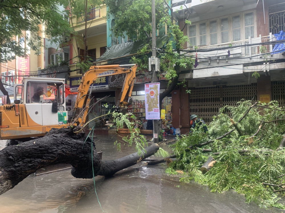 Lực lượng chức năng cắt tỉa cây gãy đổ để dọn đường cho người dân đi lại